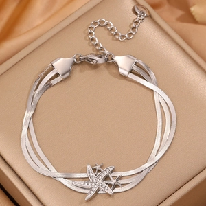 Vue macro d'un bracelet triple chaîne serpent argentée avec breloques étoile de mer