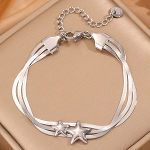 Détail du bracelet multicouche en acier argenté avec breloques étoiles et fermoir