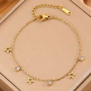 Elegant gold titanium steel bracelet with star charms and crystal pendants on jewelry box