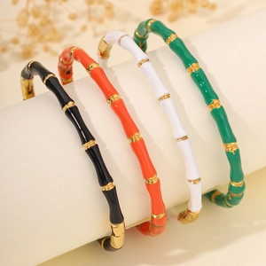 Detailaufnahme von vier farbenfrohen Edelstahl-Bambusarmbändern mit goldenen Gliedern