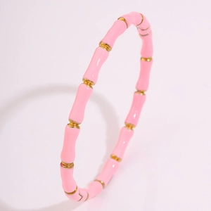 Detail eines rosa emaillierten Edelstahlarmbands im Bambus-Design mit Goldakzenten