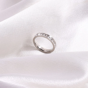 Détail d'une bague éternité en acier titane avec cristaux sur soie blanche