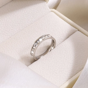Vue macro d'une bague en acier titane minimaliste sertie de zircons étincelants