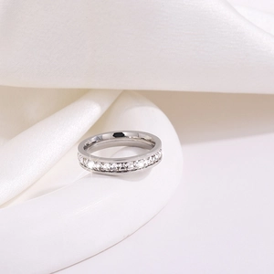 Détail de la bague d'éternité sertie de zircons carrés sur de la soie blanche