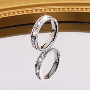 Gros plan d'une bague éternité en argent avec zircons étincelants sur surface miroir