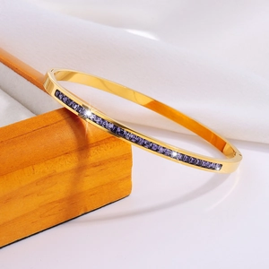 Detalle de brazalete de acero dorado con cristaux violetas de talla cuadrada engastados