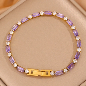 Gros plan d'un bracelet tennis doré avec zircons violets et fermoir à rabat sûr