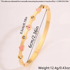 Dettaglio del bracciale dorato con cuori in smalto rosa e accenti in zircone lucido