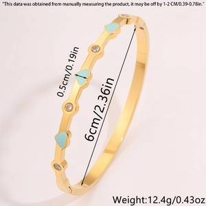 Dettaglio del bracciale a cuore dorato con smalto azzurro e particolari in zircone