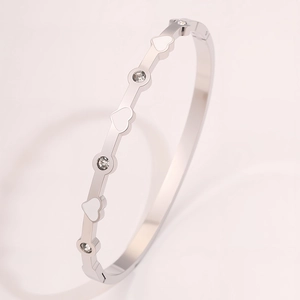 Vista macro di elementi a cuore e diamanti rotondi su un bracciale in acciaio titanio