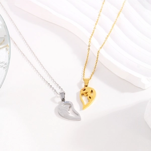 Macro detail of couple's heart-shaped split necklaces with Love You engraving