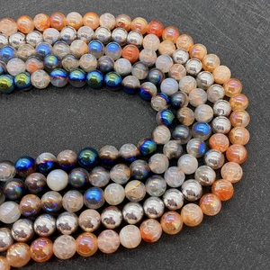 Close-up of orange crackle agate beads and silver plated charms for jewelry making