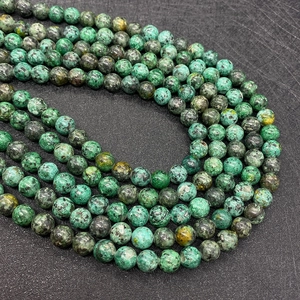 Macro shot of 8mm African turquoise round beads with natural green and black patterns