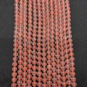 Detailed macro view of pink watermelon quartz beads with smooth polished texture