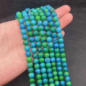 Macro detail of polished green phoenix stone round beads with natural marble texture