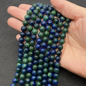 Detailed macro view of 8-10mm natural Phoenix Stone beads with blue and green textures