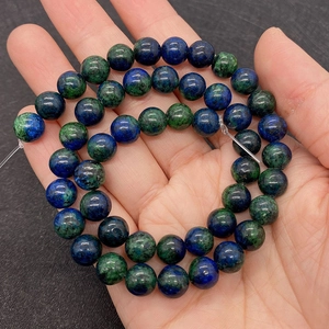 Close-up of natural Phoenix Lapis beads with unique blue and green marble texture