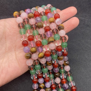Macro view of multi-colored natural stones like tiger eye and quartz beads on a red string