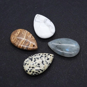 Macro detail of teardrop natural stone pendants with pre-drilled holes for DIY jewelry making