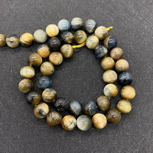 Macro detail of mixed tiger eye stone beads showing natural blue and gold textures