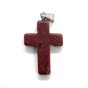 Macro shot of cross-shaped red goldstone pendant with metallic sparkles and silver bail