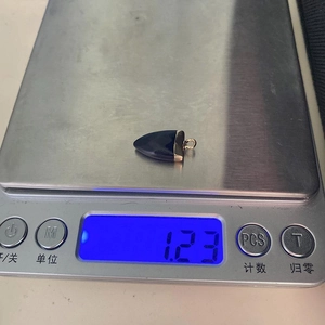 Vista detallada del colgante de piedra azul pesado en una báscula digital de joyería