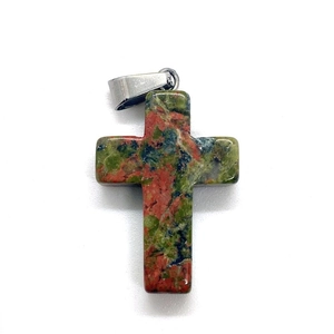 Macro view of cross pendant crafted from natural unakite stone with metal bail detail