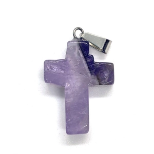 Macro shot of natural purple amethyst cross pendant with a silver metallic bail