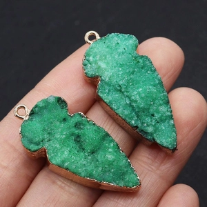 Detailopname van smaragdgroene druzy hangers met roségouden vergulde randen