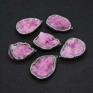 Macro detail of six pink druzy quartz pendants with sparkling rhinestone edges
