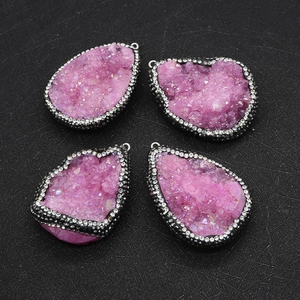 Macro detail of irregular teardrop druzy pendants with black metal and white rhinestones