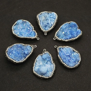 Vue détaillée de six pendentifs en agate druzy bleue avec bords en micropavé métallique