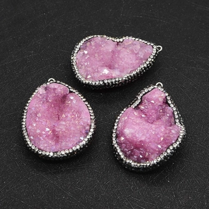 Macro shot of three pink druzy stone pendants with sparkling crystal borders