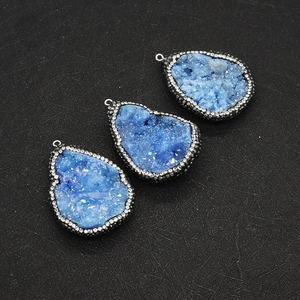 Détail macro de pendentifs en agate de cristal bleu en forme de goutte et strass brillants
