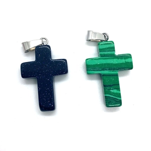 Blue goldstone and green malachite cross pendants with silver clasps on white background
