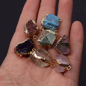 Macro view of irregular amethyst and natural stone connectors with gold plated edges