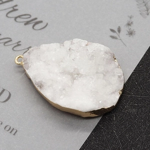 Detailed view of irregular white druzy crystal pendant with gold electroplated edge