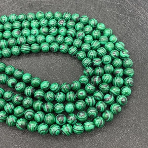 Dettaglio macro di perle di malachite verde con venature uniche per la creazione di gioielli