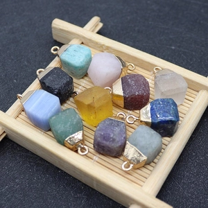 Top view of ten different natural square stone pendants displayed on a bamboo tray