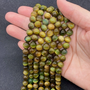 Détail macro de perles naturelles en œil de tigre avec effet œil de chat poli jaune et vert