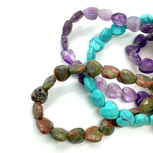 Detailed macro view of faceted heart-shaped natural stone beads in mixed colors