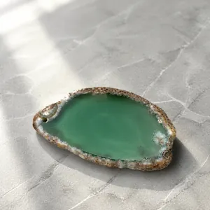 Detail showing measurement of natural green agate stone slice pendant using calipers