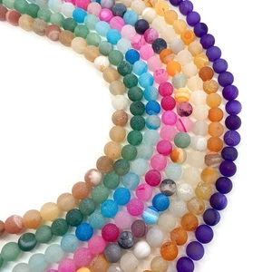 Matte natural agate beads in multiple vibrant colors arranged in a rhythmic arc pattern