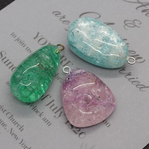 Détail de pendentifs en cristal de pierre naturelle irrégulière aux tons vert, violet et bleu