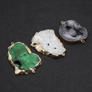 Détail de pendentifs en druse naturelle avec bords plaqués or et connecteurs doubles