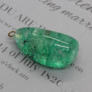 Détail macro d'un pendentif en cristal vert irrégulier avec boucle en métal pour DIY