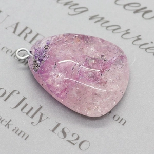 Détail macro d'un pendentif en cristal violet naturel avec une bélière argentée