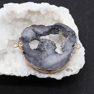 Détail macro d'une tranche de quartz druzy naturel avec bordure dorée et doubles attaches