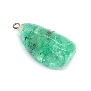 Pendentif en cristal vert irrégulier avec boucle en bronze sur fond blanc épuré