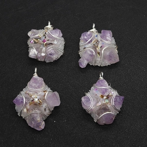 Detailed view of four handmade silver wire wrapped raw amethyst crystal pendants
